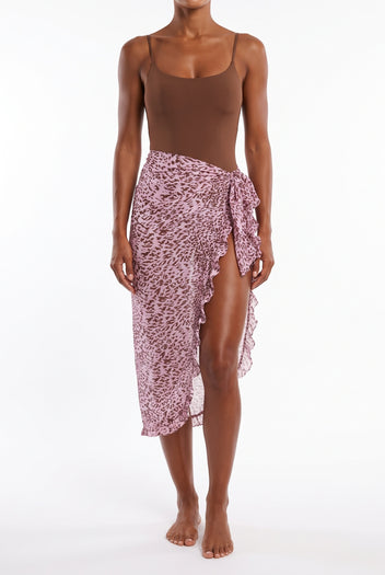 Model wearing pink print sheer sarong skirt with ruffle edge over brown bodysuit, front view