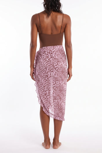 Model seen from behind wearing pink print sheer sarong skirt with ruffle hem over brown bodysuit