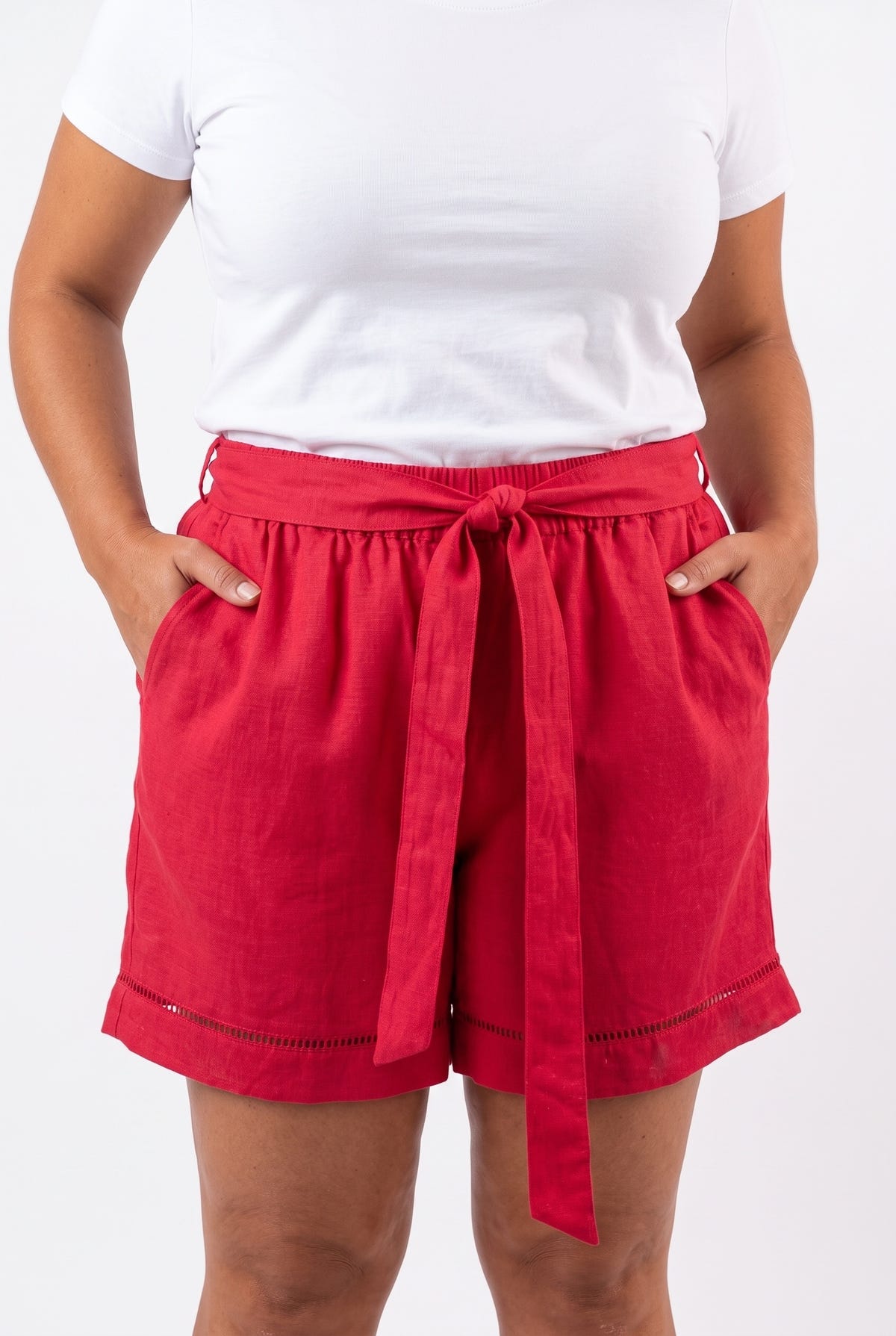 Model wearing fuchsia linen blend shorts with tie belt and hands in pockets, front view, plus size