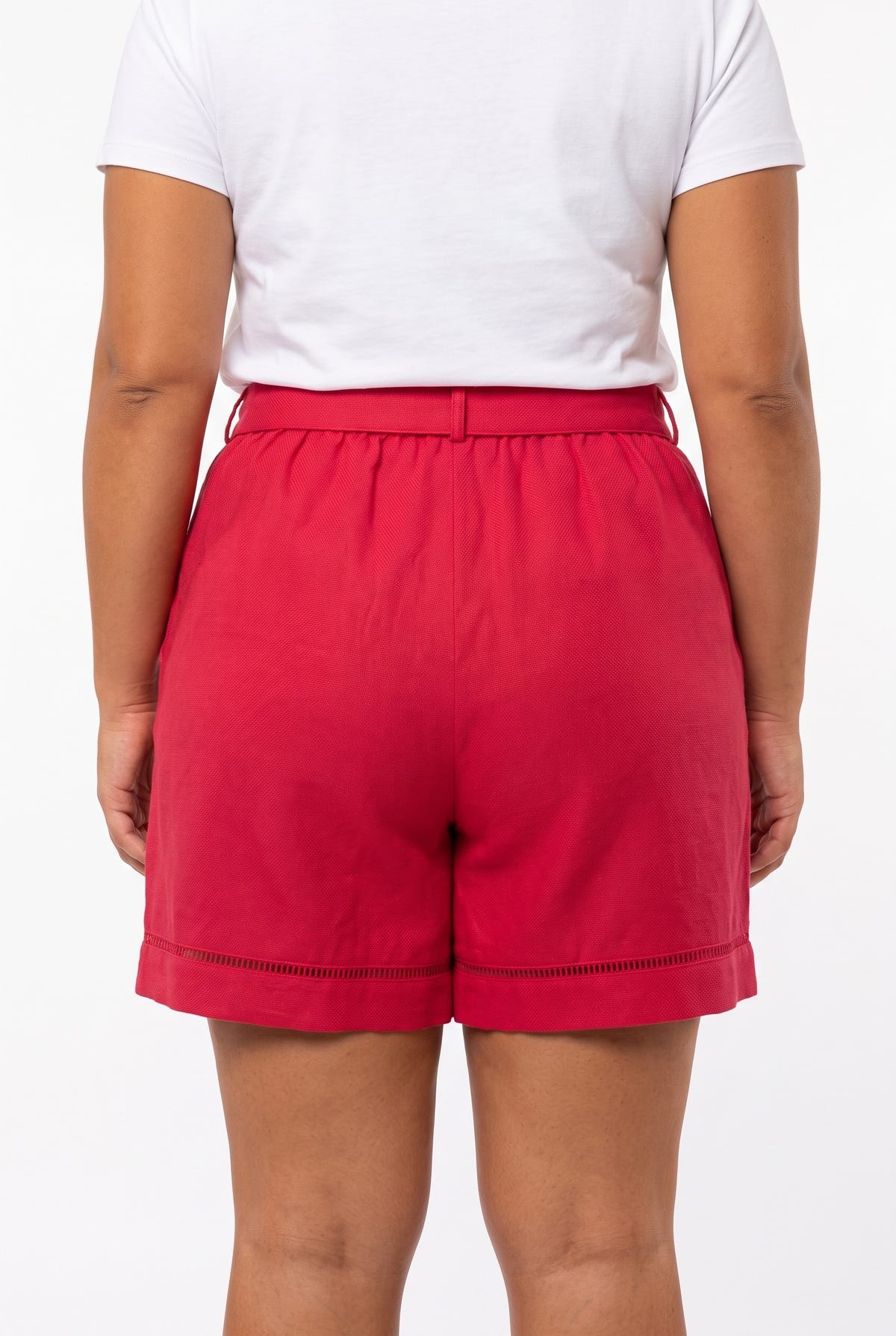 Model seen from behind wearing fuchsia linen blend shorts with cuffed hem and white t-shirt, plus size