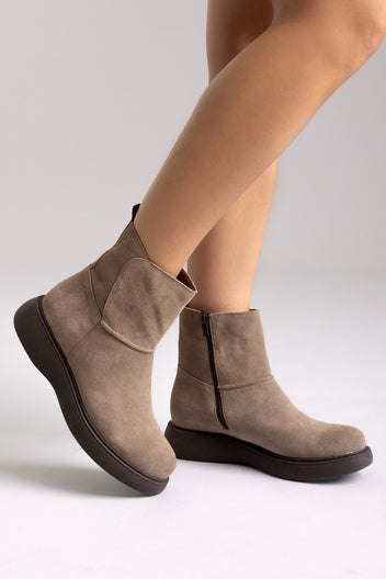 Taupe suede ankle boots worn, angled view showing zip closure and thick sole