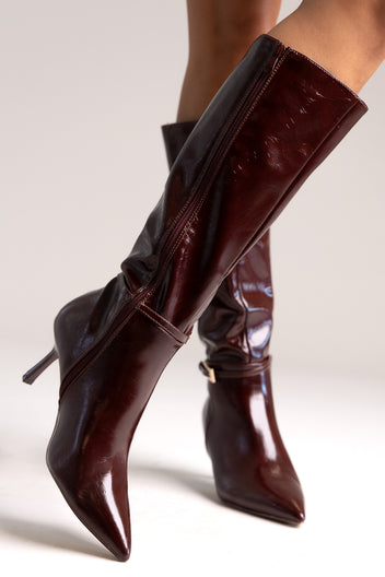 Dark burgundy patent faux leather knee-high boots with pointed toe and stiletto heel, close-up angled view
