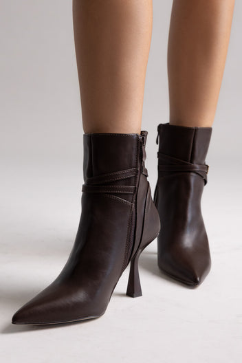 Dark brown leather pointed-toe ankle boots with stiletto heel and side strap, angled view on a model