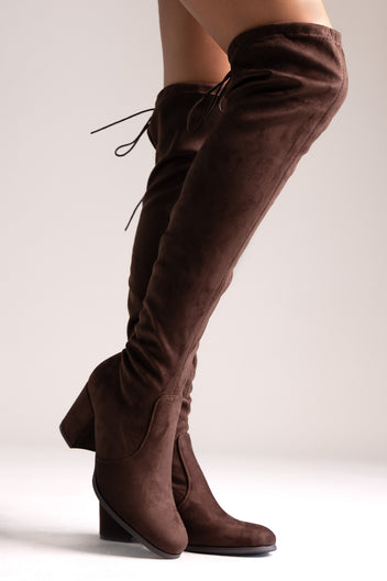Brown faux suede over-the-knee boots with drawstring tie and block heel, side view on a model's legs