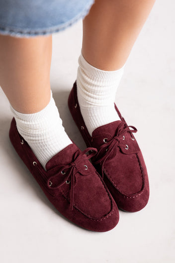Dark burgundy faux suede stiletto ankle boots with pointed toe, front view on a model in jeans