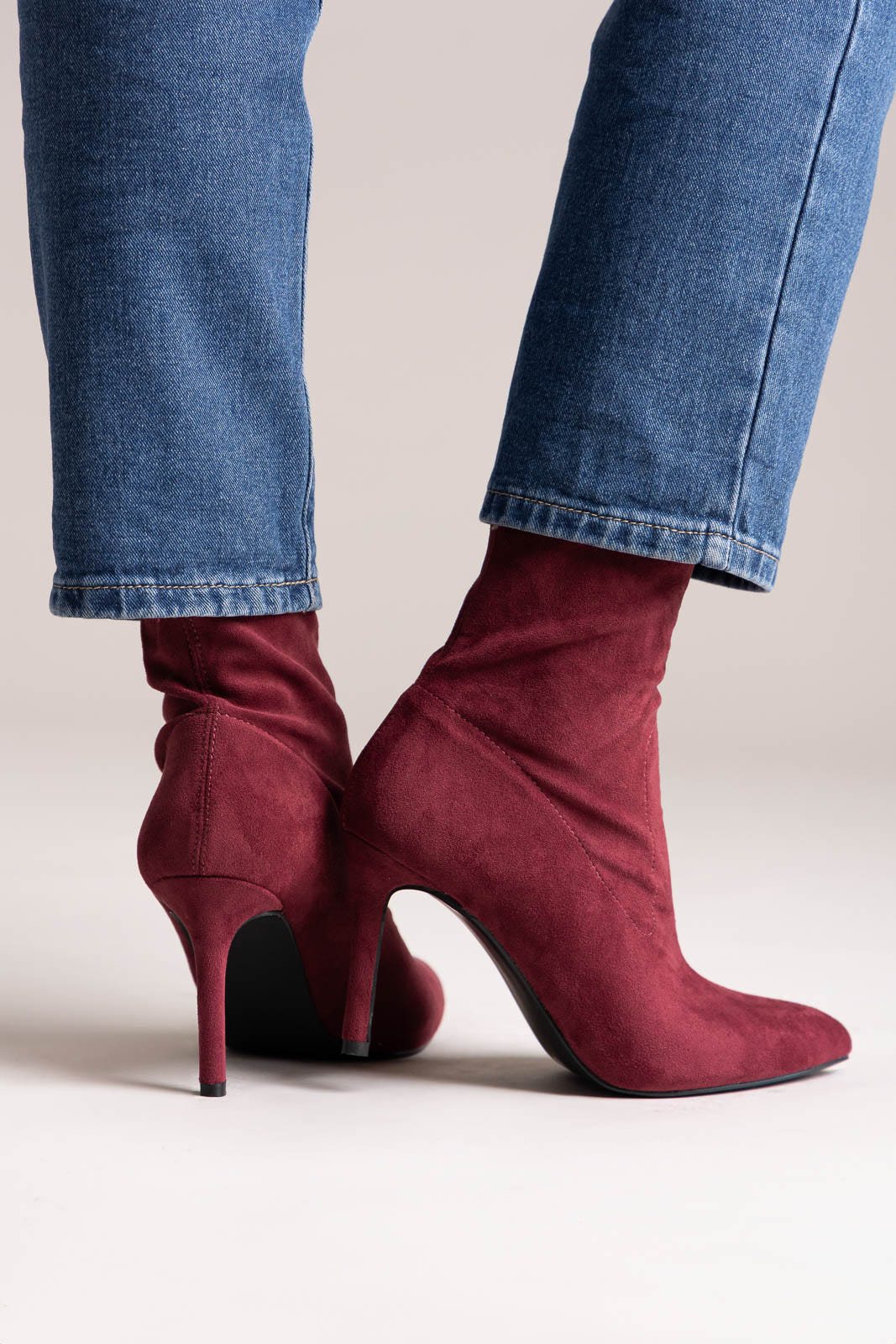 Tan faux suede western ankle boots with stitched shaft and stacked block heel, rear view on a model