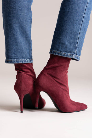 Tan faux suede western ankle boots with stitched shaft and stacked block heel, rear view on a model