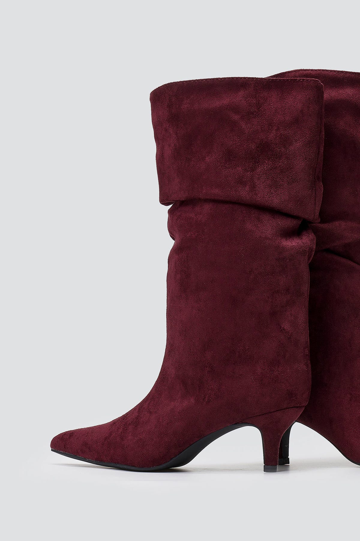 Burgundy faux suede slouchy calf boots with pointed toe and kitten heel, close-up on grey