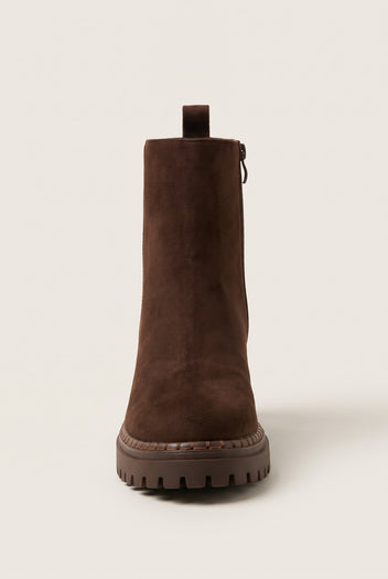 Back view of mocha brown suede ankle boot with center pull tab at the heel and rugged lugged sole edge