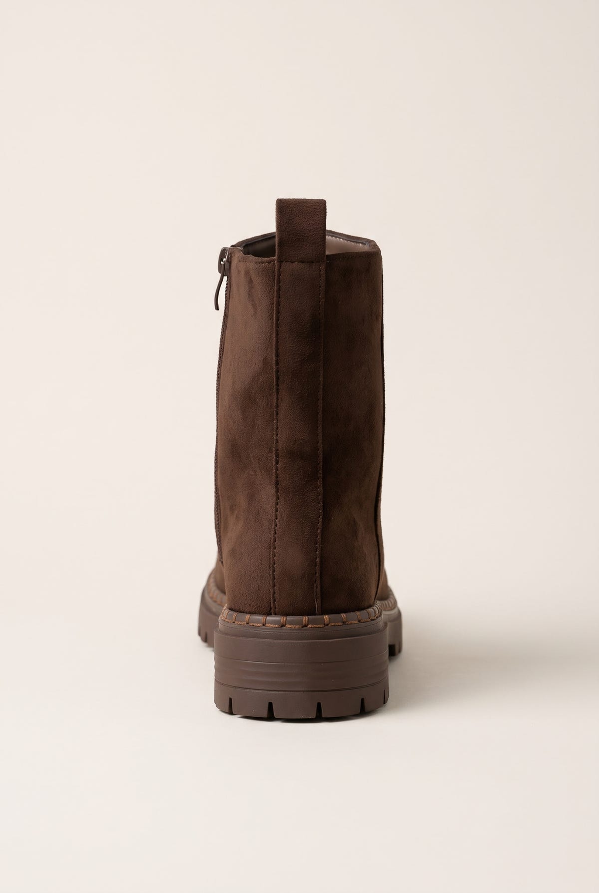 Back view of mocha brown suede ankle boot showing vertical zipper seam, heel pull tab and lugged sole