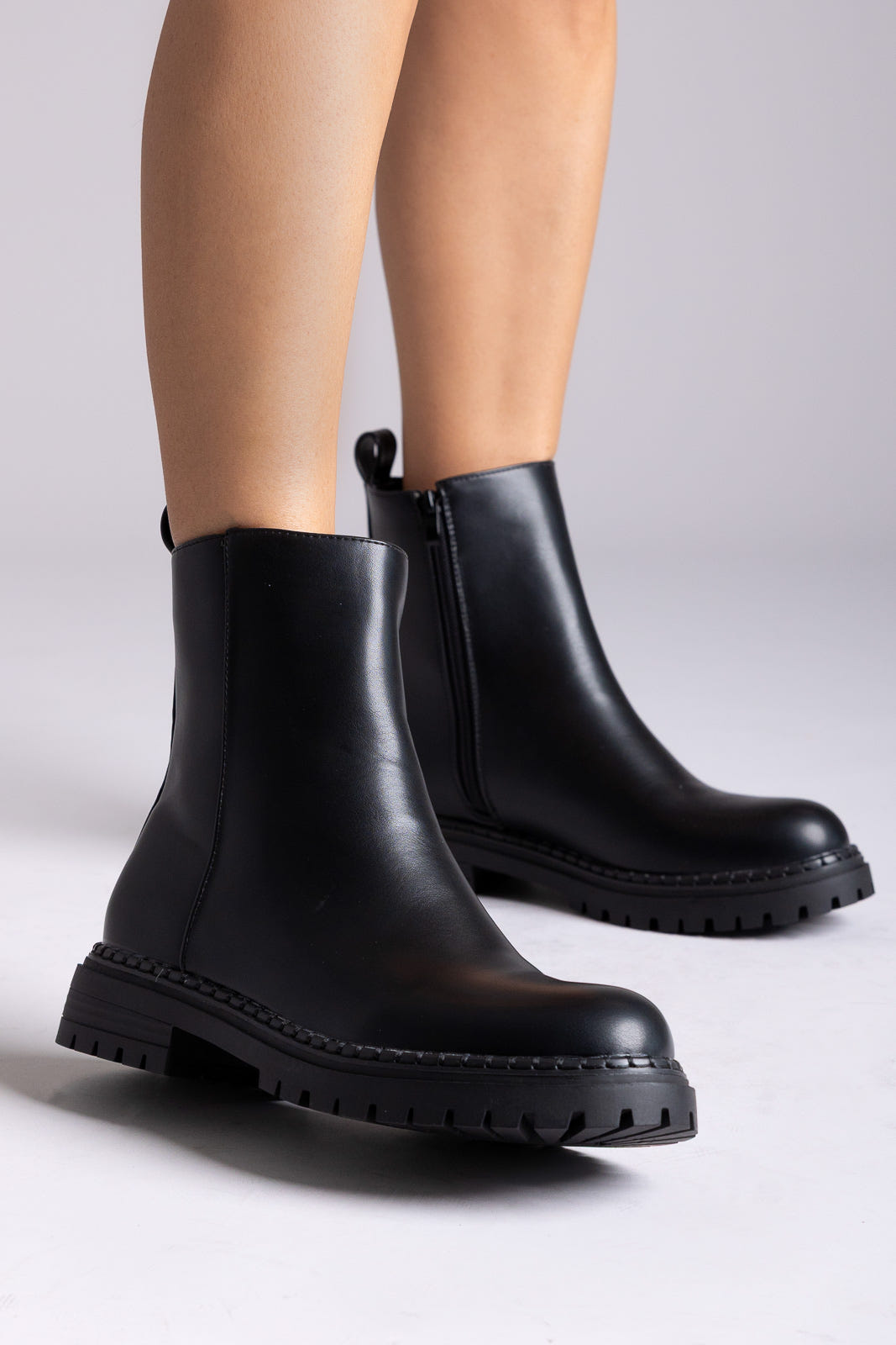 Black matte ankle boots with side zipper and chunky sole, worn on foot – TFP