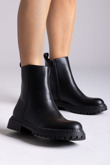 Black matte ankle boots with side zipper and chunky sole, worn on foot – TFP
