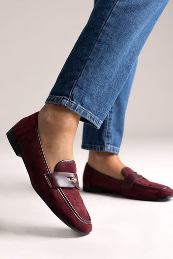 Burgundy suede loafers with leather trim and gold-tone bit, side view on a model