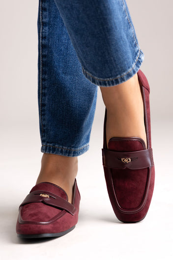 Burgundy suede loafers with leather trim and gold-tone bit, front view on a model