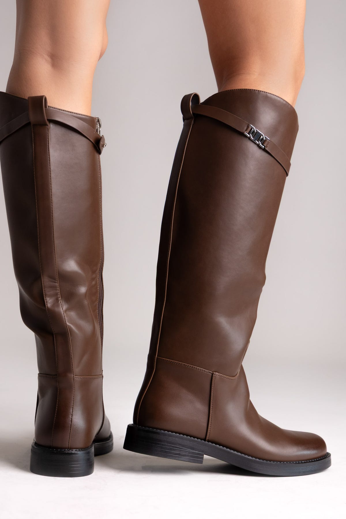 Burgundy croc-embossed faux leather knee-high boots with pointed toe and block heel, angled view on a model