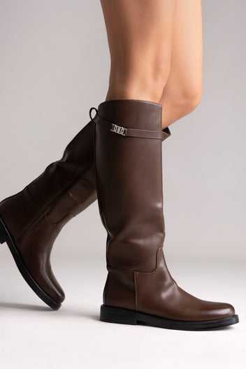 Brown leather knee-high riding boots with silver buckle strap, close-up of the strap on a model