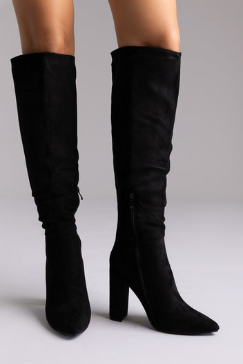 Black suede over-the-knee boots with pointed toe and block heel, standing side by side on light backdrop