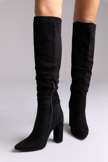 Black suede over-the-knee boots with pointed toe and block heel, standing side by side on grey backdrop