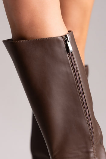 Brown leather knee-high riding boots with side zip, close-up detail of the shaft on a model