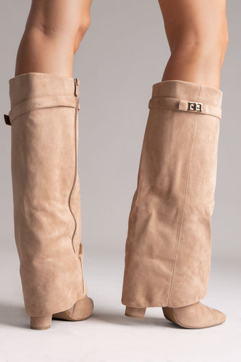 Taupe suede fold-over knee-high boots with gold buckle strap and block heel, rear view on a model