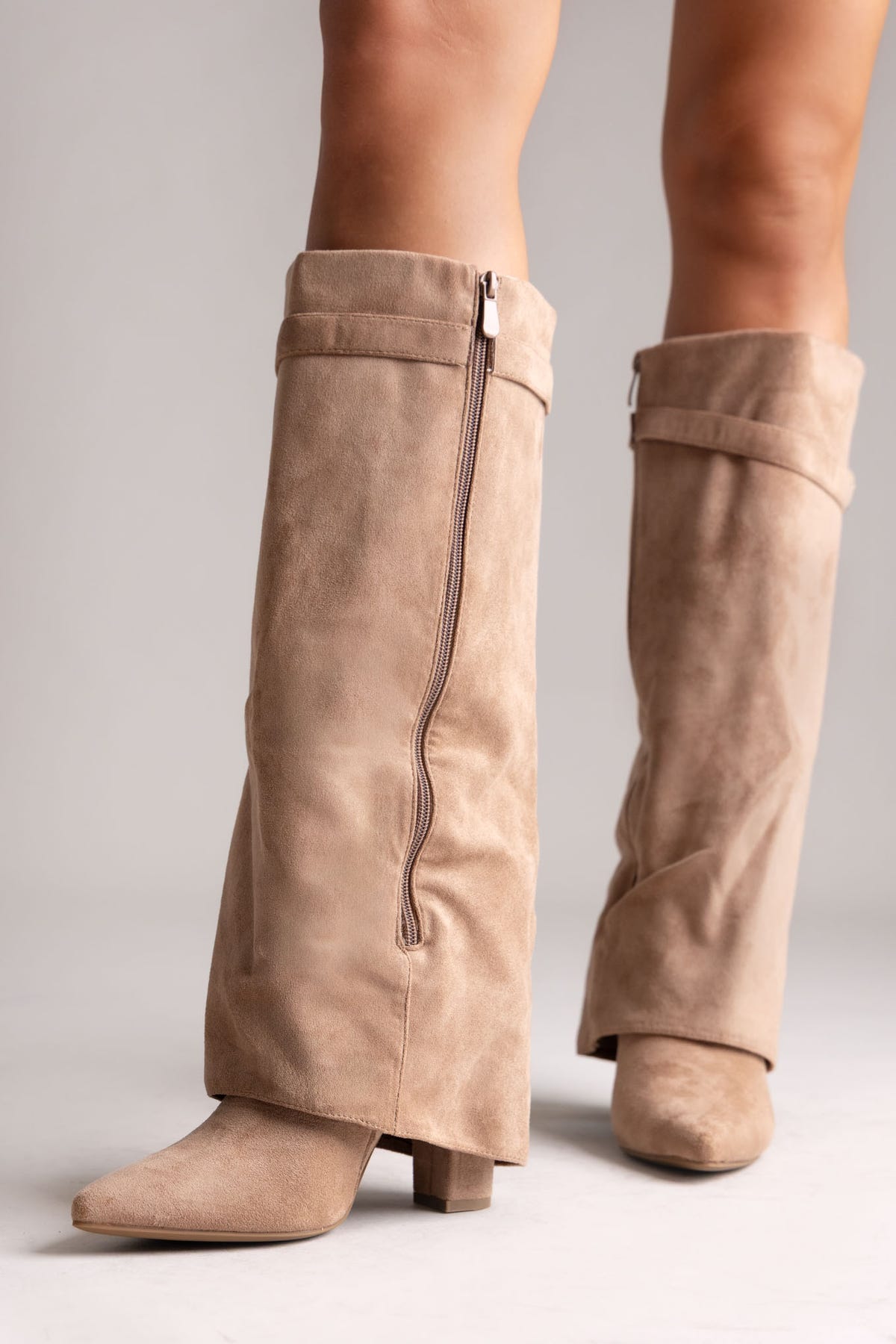 Taupe suede fold-over knee-high boots with side zip and block heel, side view on a model