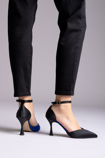 Black satin ankle-strap pumps with blue accent at the inner arch and flared heel, rear view with black jeans