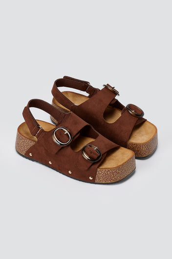 Pair of brown suede platform sandals with two buckled straps, slingback strap and cork-style sole, three-quarter view