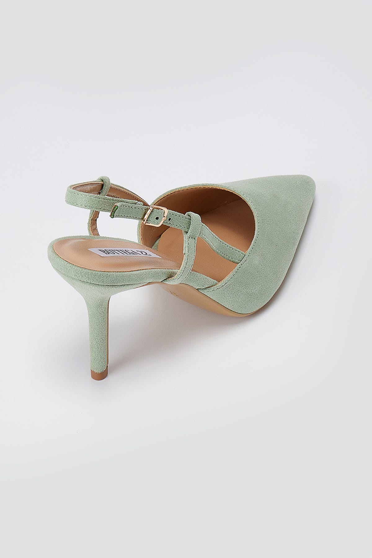 Mint green suede slingback pump, back three-quarter view, showing the gold buckle ankle strap, tan lining and slim heel