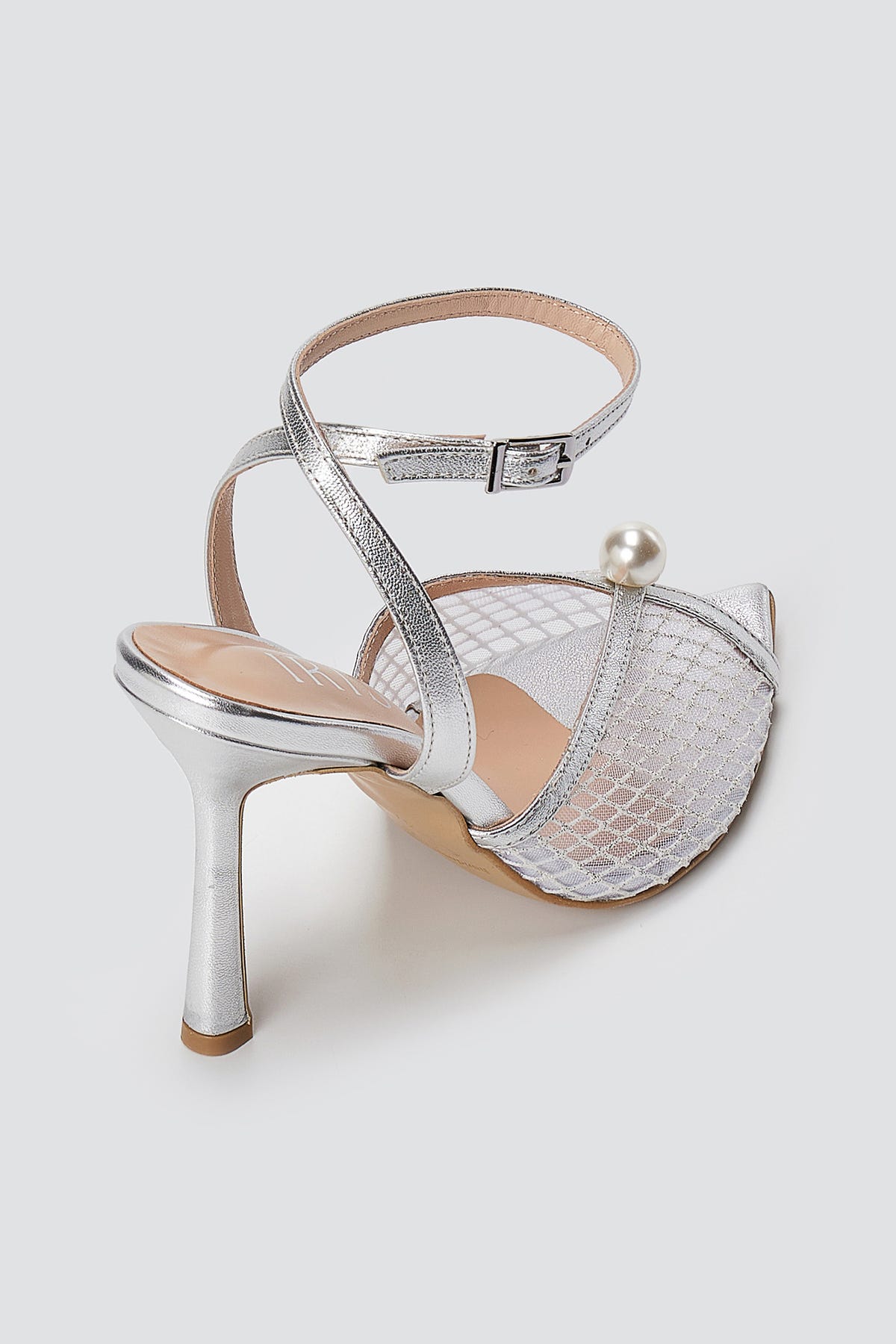 Silver metallic sandal with clear mesh front, pearl bead, ankle strap and slim high heel, back three-quarter view