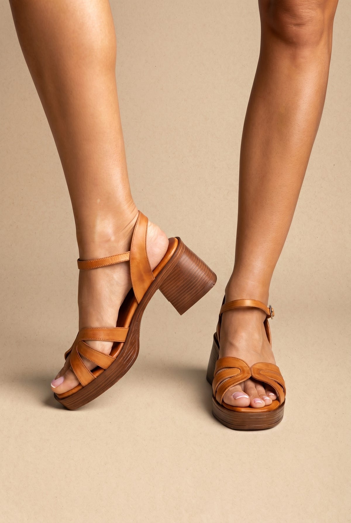 Tan leather platform block-heel sandals with strappy front and ankle strap, worn on a model, front view