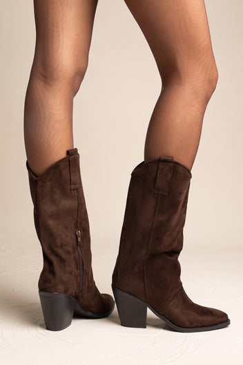 Model wearing brown suede western gaiter boots with block heels and pointed toes over sheer tights