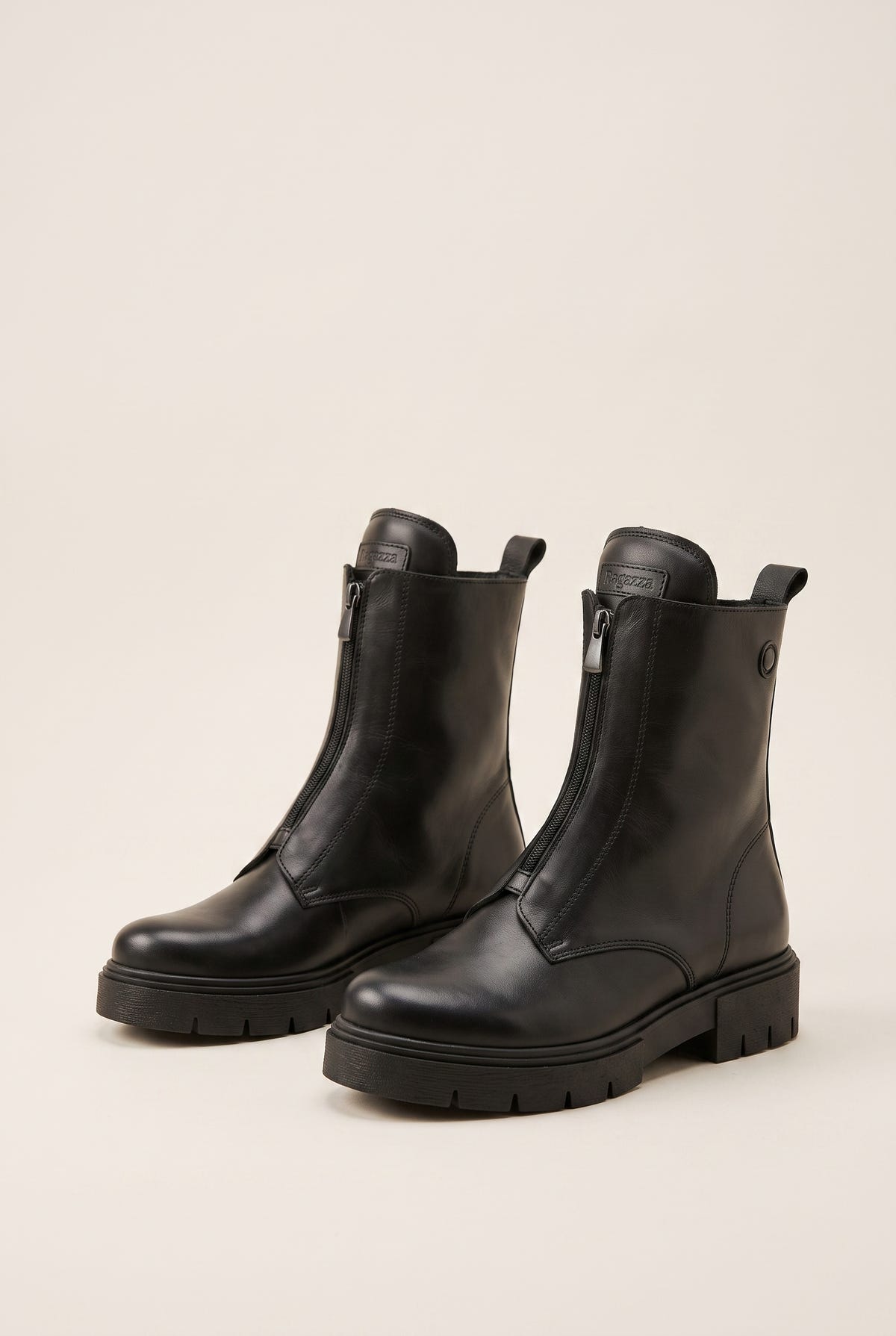 Black leather lug-sole ankle boots with side zip, pair in angled view on a light beige background