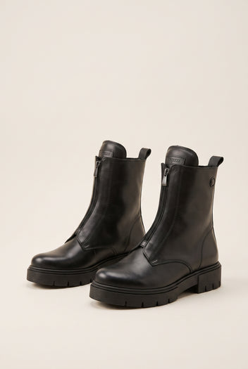 Black leather lug-sole ankle boots with side zip, pair in angled view on a light beige background