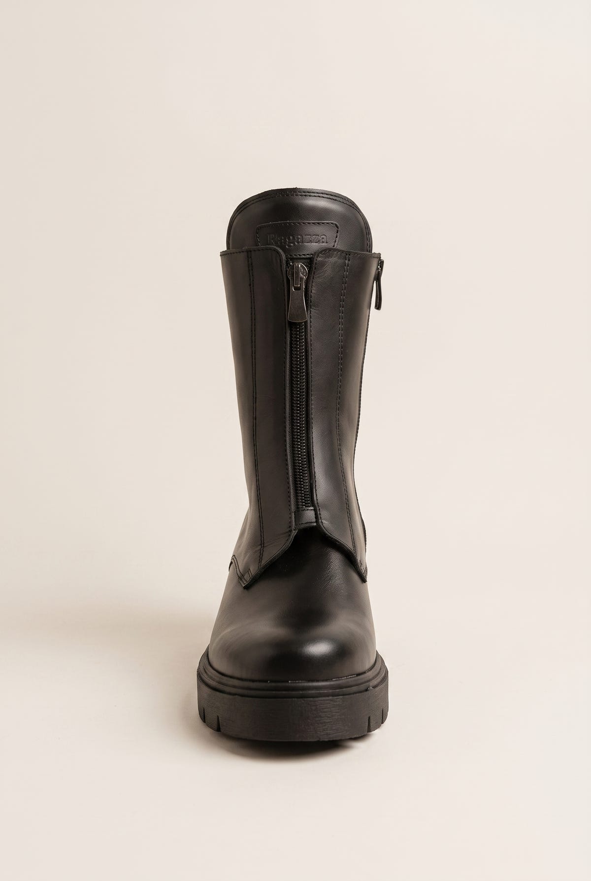 Black leather knee-high boots with lug sole and back zip, front view on a light beige background