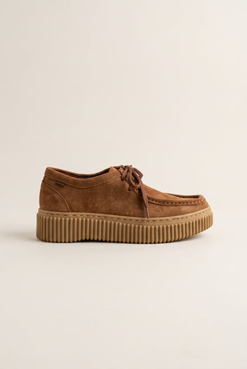 Tan suede lace-up creeper shoe with crepe rubber sole, outer side view on a light beige background