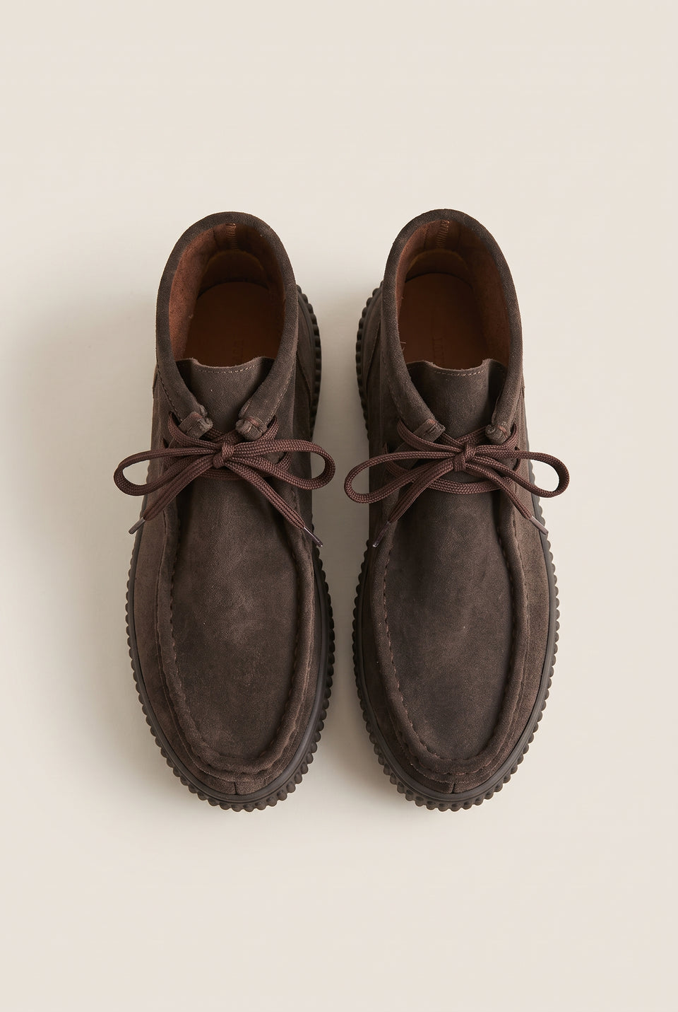 Pair of dark brown suede lace-up ankle boots, top-down view, moccasin toe stitching and tied laces