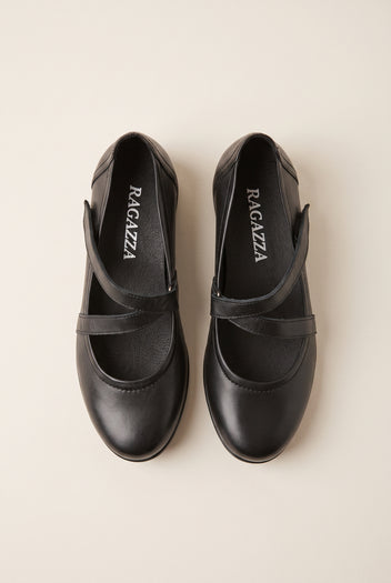 Overhead view of a pair of black leather Mary Jane flats with crossover straps and rounded toes