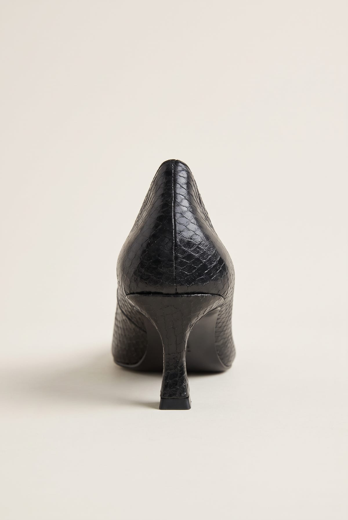 Back view of black snake-effect pump showing the pointed heel counter and slender kitten heel