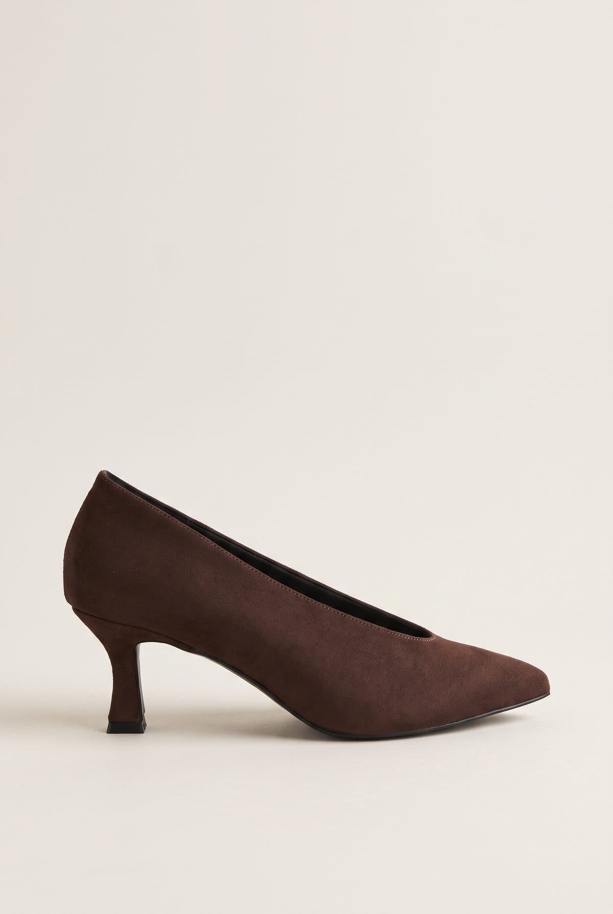 Side view of brown suede pointed-toe pump with a low-cut vamp and a slim kitten heel