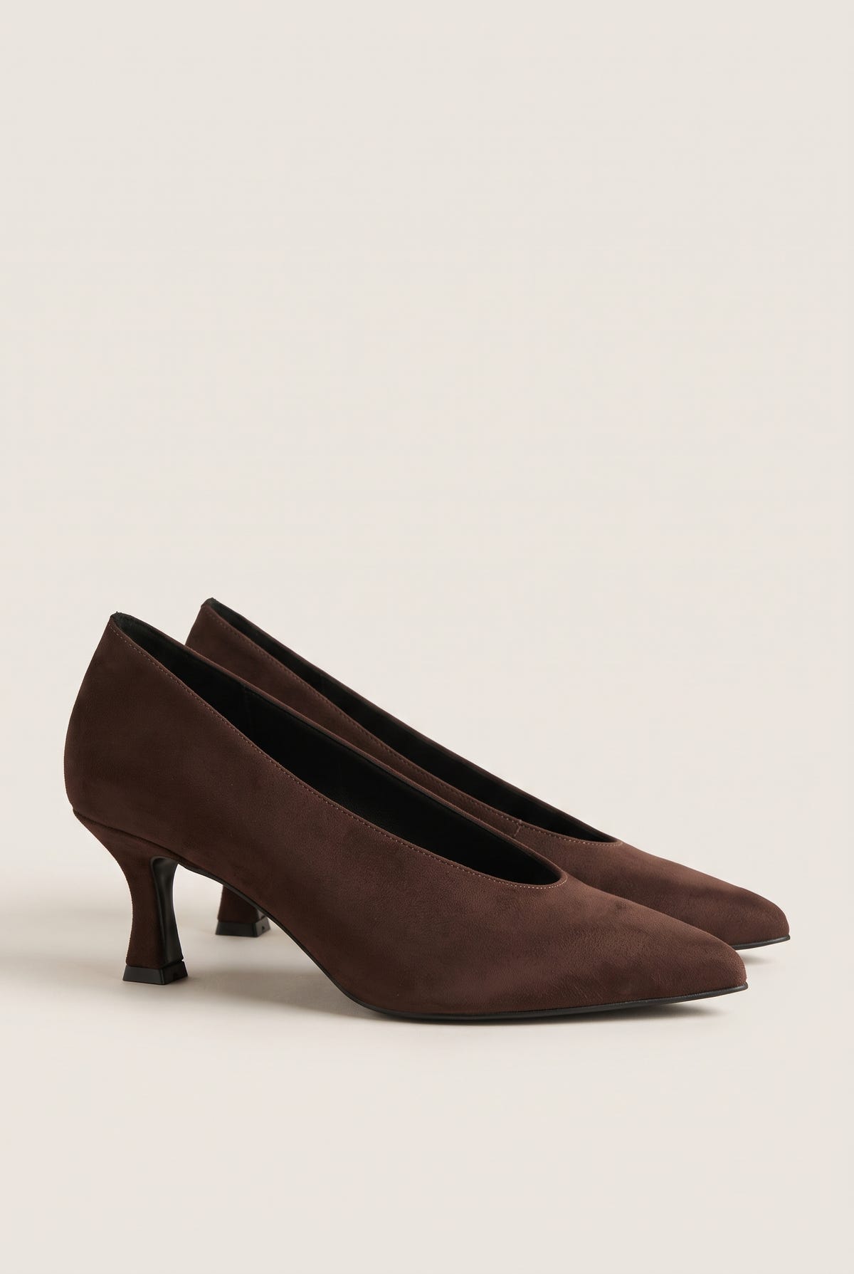 Pair of brown suede pointed-toe kitten heel pumps placed side by side on a light surface