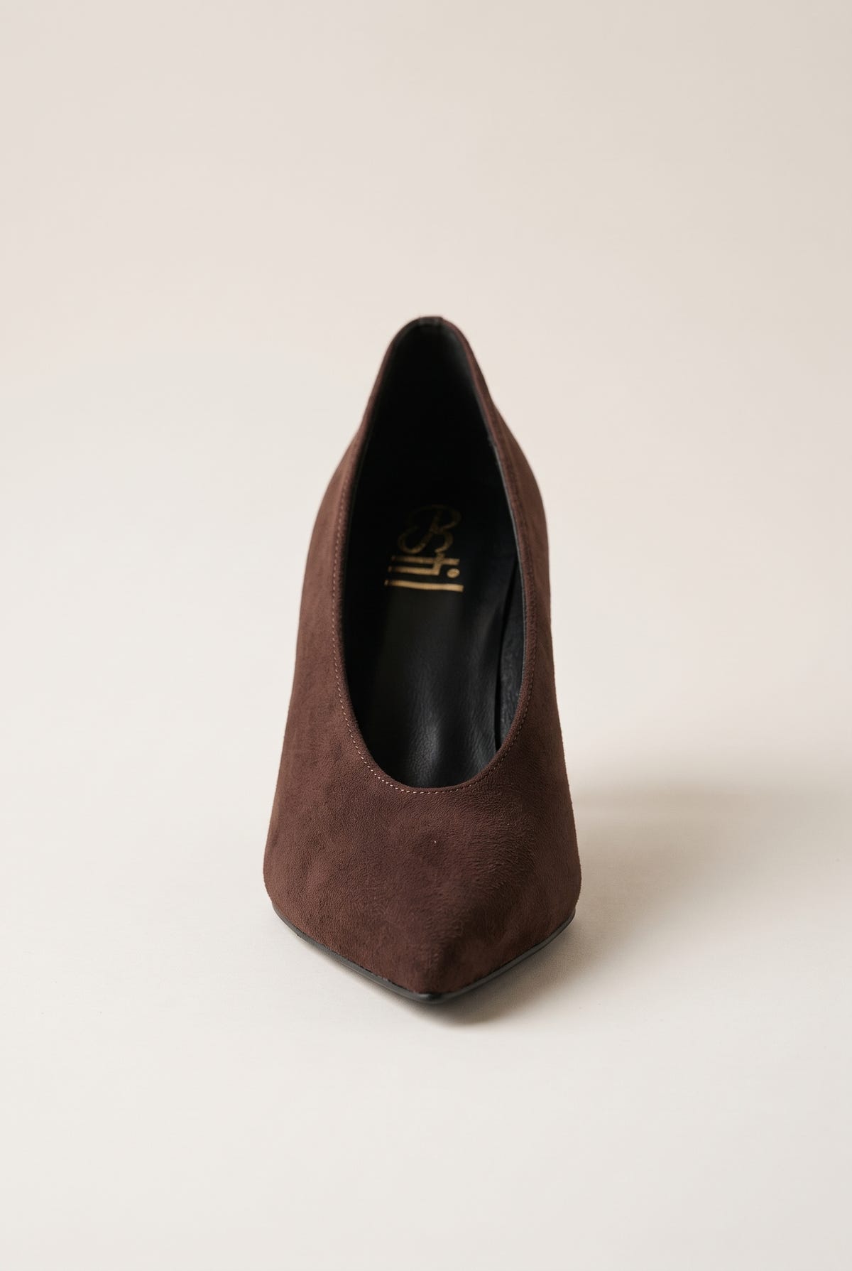 Front view of brown suede pump showing the narrow pointed toe and smooth low-cut vamp