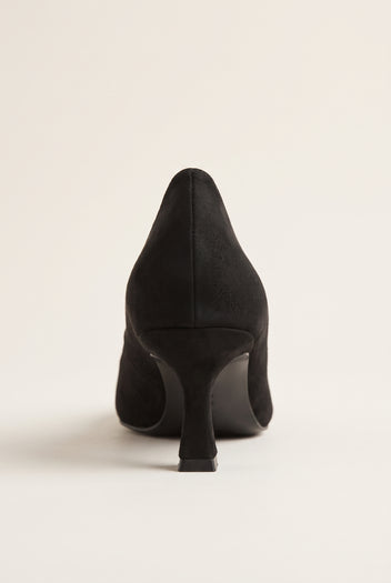 Back view of black suede pump with a smooth heel counter, slim kitten heel and clean rounded sole edge