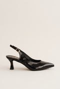 Side view of black patent slingback with pointed toe, gold-tone buckle strap and slim kitten heel