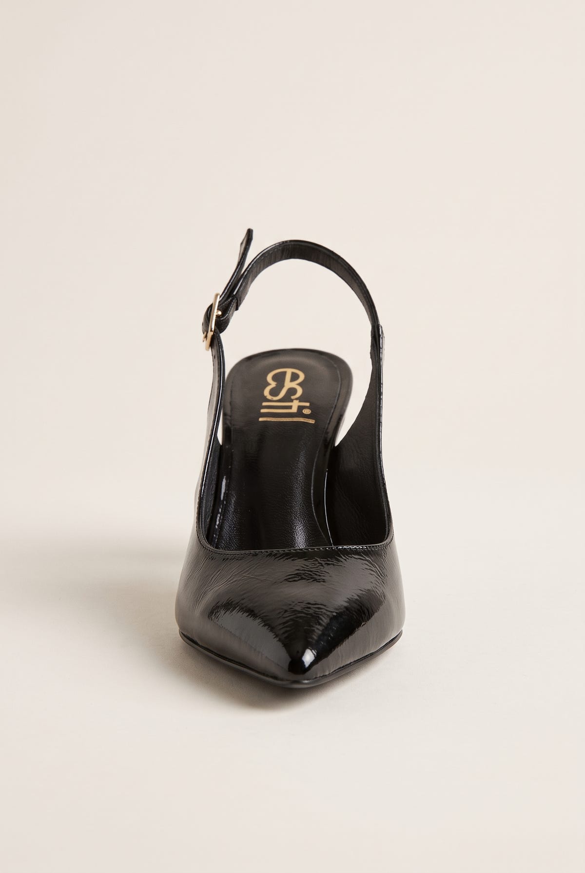 Front view of black patent slingback with pointed toe and buckled strap behind the heel