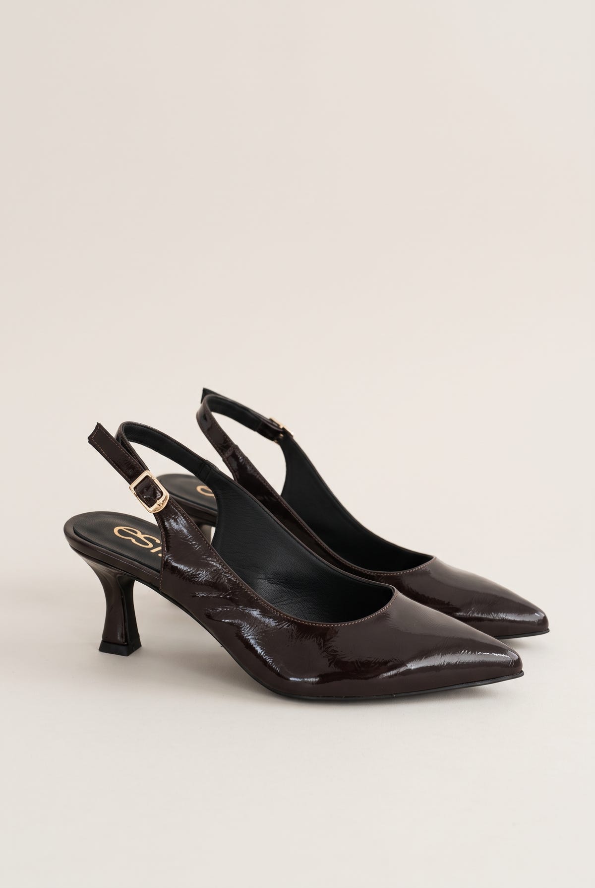 Pair of brown patent slingback pumps with buckled straps and pointed toes, seen from the side