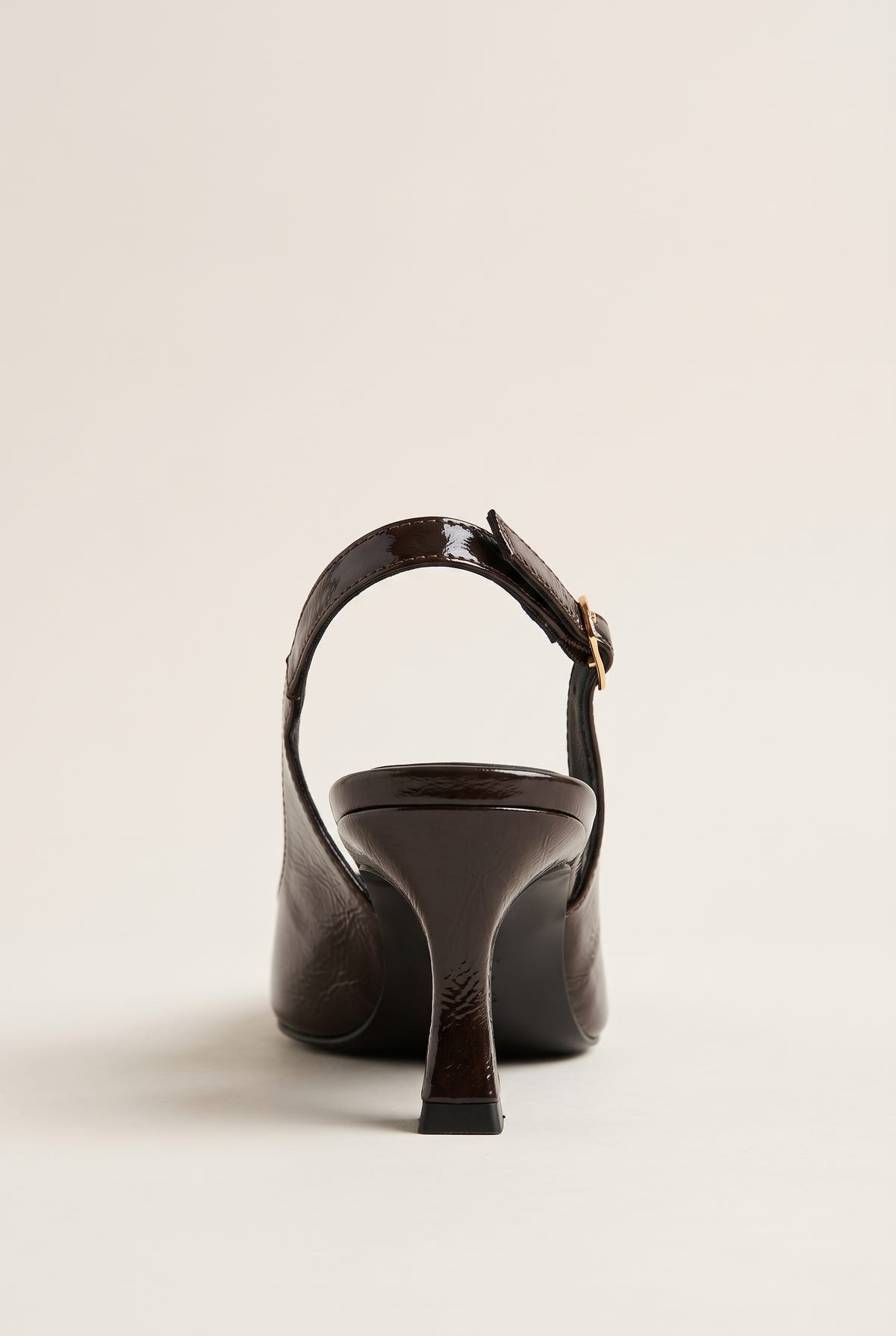 Back view of brown patent slingback showing the buckled strap and narrow kitten heel
