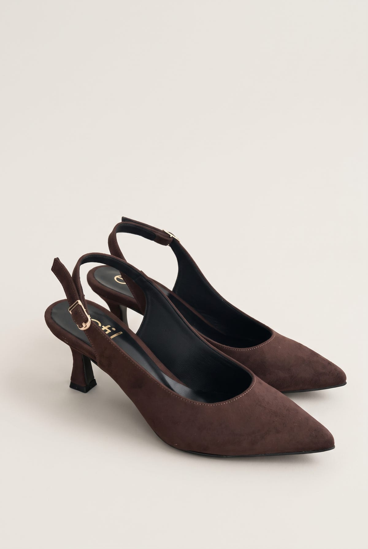 Pair of brown suede slingback pumps placed side by side with buckled ankle straps and pointed toes