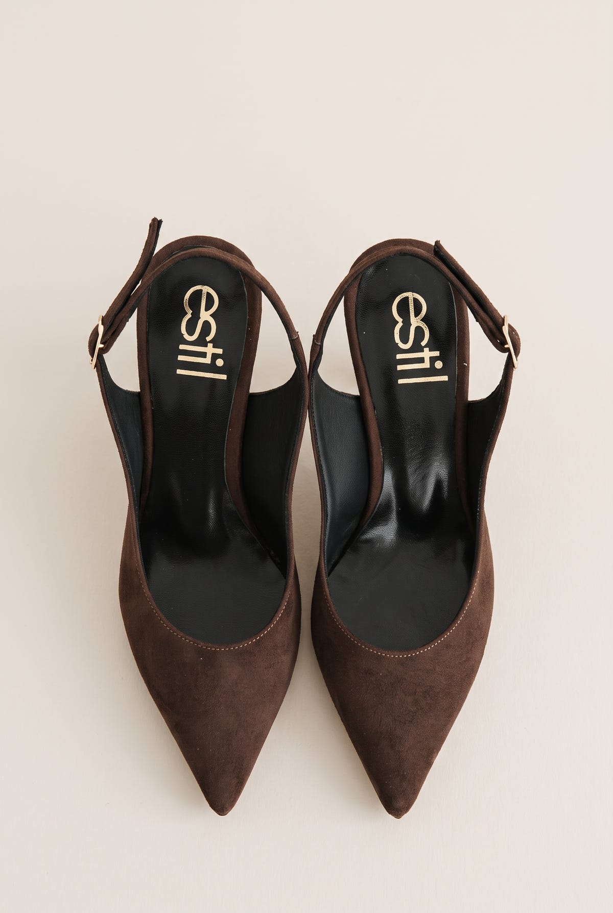 Top view of brown suede slingback pumps with buckled straps, pointed toes and dark leather insoles