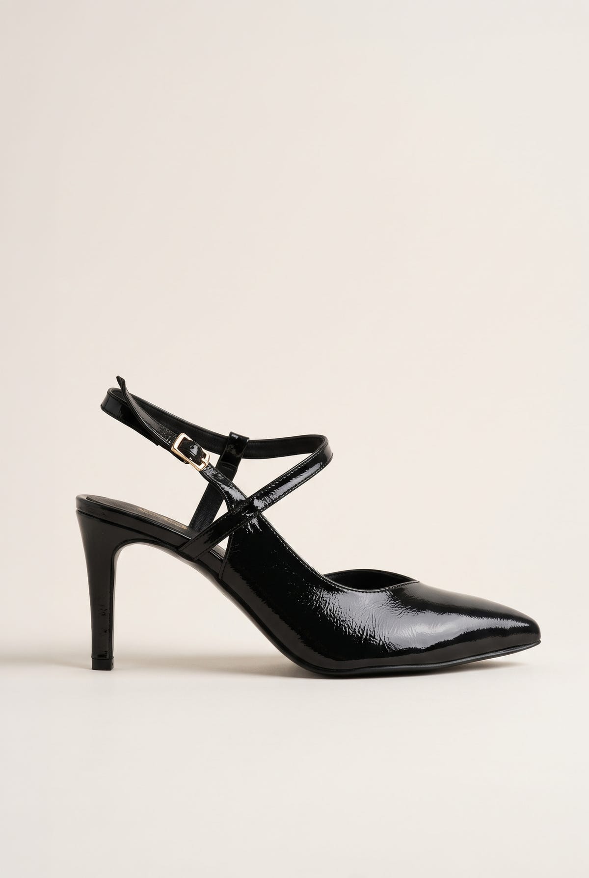 Side view of a black patent pointed toe slingback pump with a crossed ankle strap and slim high heel