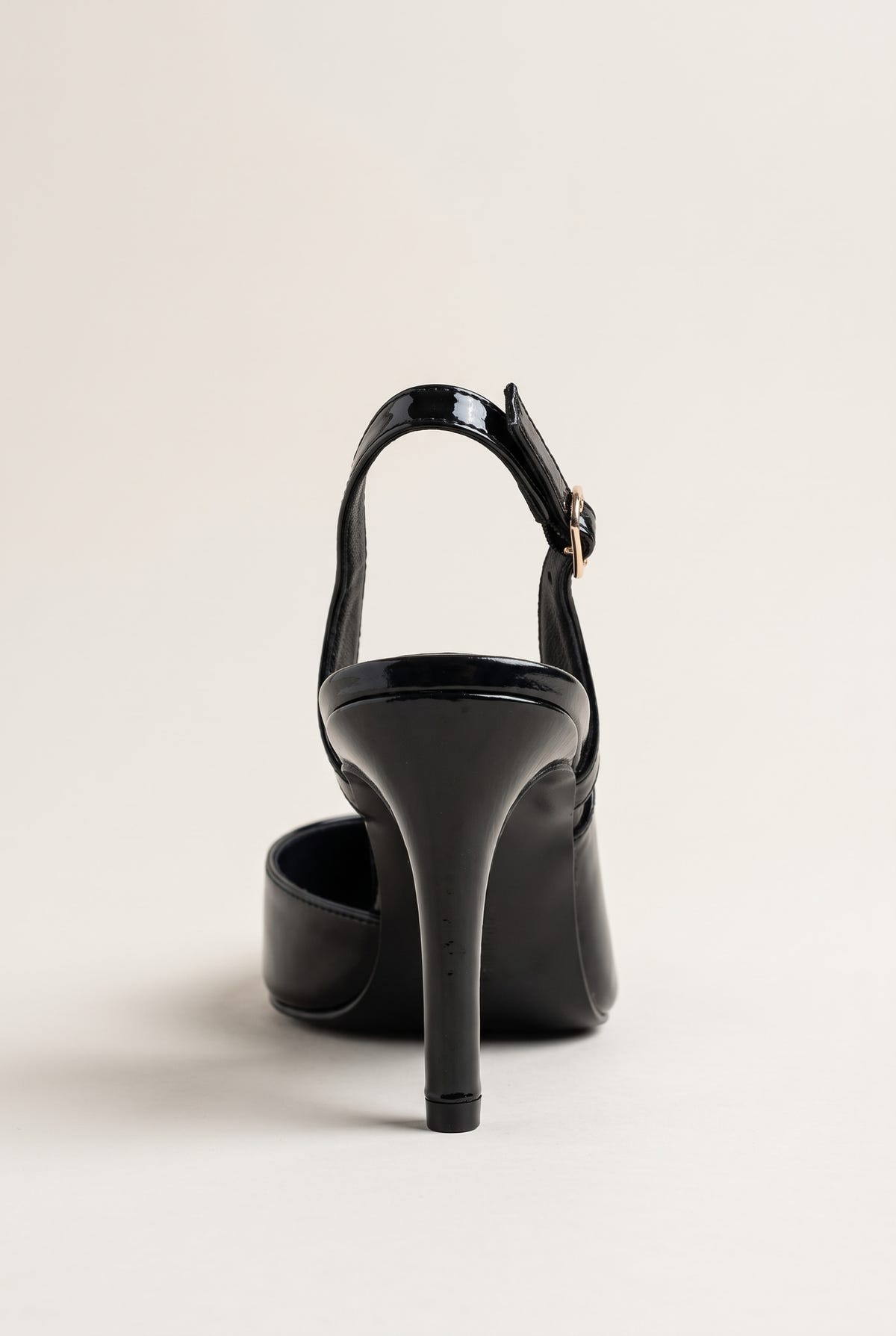 Back view of a black patent slingback pump showing the open heel, ankle strap and slim heel